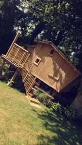 a large wooden house sitting on top of a field at La cabane perchée du trappeur in Écrainville