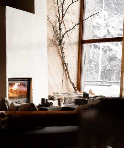 een woonkamer met een bank en een open haard bij Preikestolen BaseCamp in Jørpeland