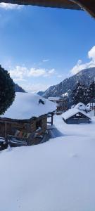 a snow covered roof of a building with snow on it at Devropa Heights in Malāna