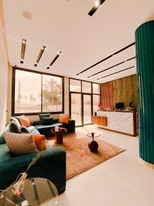 a living room with a green couch and a kitchen at TIMAZIN HOTEL DAKHLA in Dakhla