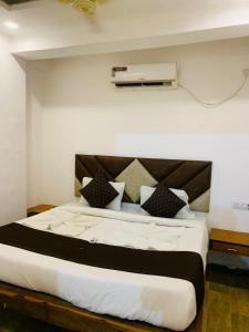 um quarto com uma cama grande e almofadas pretas e brancas em 1 Bhk Apartment 200 mtr from beach em Calangute