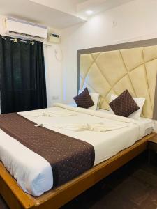 1 dormitorio con 1 cama grande y cabecero grande en 1 Bhk Apartment 200 mtr from beach en Calangute
