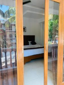 a sliding glass door with a bed in a room at 1 Bhk Apartment 200 mtr from beach in Calangute