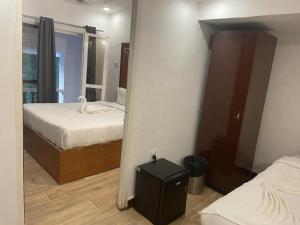 a small bedroom with two beds and a mirror at 1 Bhk Apartment 200 mtr from beach in Calangute