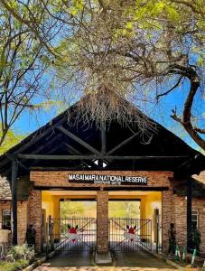 a building with a sign on the front of it at Maasai home village in Sekenani