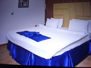 a large white bed with a blue cloth on it at VILLA TOSCANA asaba in Okpanam