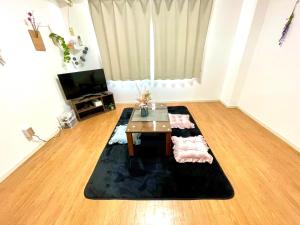 a living room with a table on a rug at FUKUOKA airport line Ijiri st self check in apartment in Fukuoka