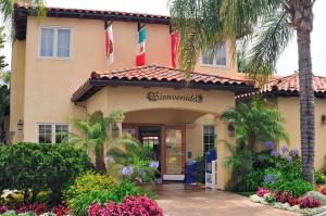 a building with palm trees and flowers in front of it at Old Town Inn in San Diego