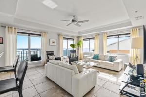 a living room with white furniture and a view of the ocean at The Wave 302 in New Smyrna Beach