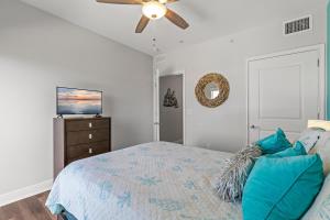 a bedroom with a bed and a ceiling fan at The Wave 302 in New Smyrna Beach +45 photos