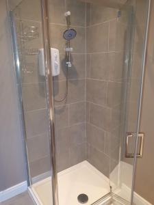 cabina de ducha con puerta de cristal y ducha en The Savile, Luxury Apartment Leeds - Your Next Stay, en Leeds