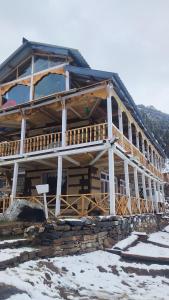 a large wooden building with snow on the ground at Devropa Heights in Malāna