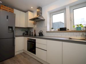 a kitchen with white cabinets and a stainless steel refrigerator at Pass the Keys Charming 2 bed apartment in London