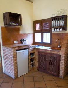 uma cozinha com um balcão de tijolos e um lavatório em Paraje del Hueznar em Cazalla de la Sierra