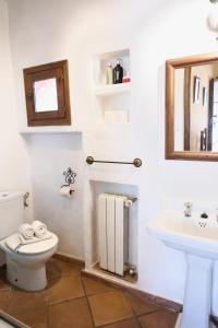 a bathroom with a toilet and a sink at Paraje del Hueznar in Cazalla de la Sierra