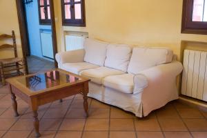 a living room with a white couch and a coffee table at Paraje del Hueznar in Cazalla de la Sierra