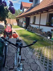 uma bicicleta estacionada em frente a uma casa em Cztery Pory Warmii Pluski pokoje do wynajęcia em Pluski