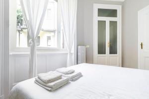 a white bedroom with towels on a white bed at Milano Cordusio in Milan