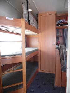 - une petite chambre avec des lits superposés dans un bus dans l'établissement Wohnwagen mit festem Vorzelt - all incl., à Fehmarn