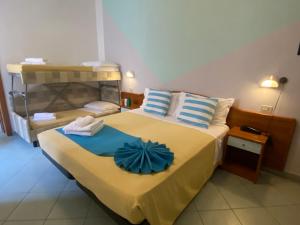 a bedroom with a large bed with towels on it at Hotel Villa Caterina in Rimini