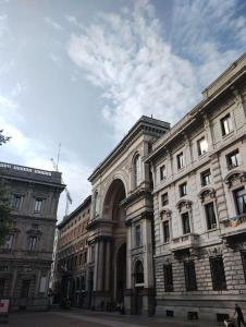 a large stone building with an arch in a street at Milano Cordusio in Milan