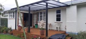 a pergola on a deck of a house at The_Cozy_Batch With a rural view in Whanganui