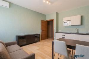 cocina y sala de estar con sofá y mesa en Einaudi Guesthouse by Apulia Accommodation, en Bari