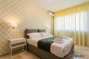 1 dormitorio con 1 cama con toallas en Einaudi Guesthouse by Apulia Accommodation, en Bari