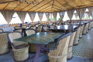 rzędu stołów i krzeseł w restauracji w obiekcie Unique Resort And Restaurant w mieście Porbandar