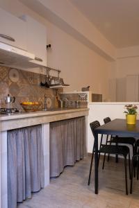 a kitchen with a table and a dining room at Affittacamere le scale in Castellammare del Golfo