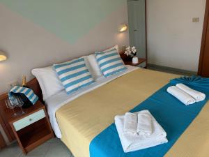 a bedroom with two beds with towels on them at Hotel Villa Caterina in Rimini