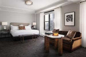 a bedroom with a bed and a couch and a table at The Talbott Hotel in Chicago