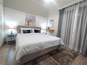 a bedroom with a large white bed and curtains at Luxury seafront house nearby Delphi in Kírra