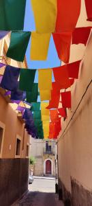 Grupa kolorowych parasoli wiszących na ulicy w obiekcie B&B Porta della Terra w mieście Militello in Val di Catania