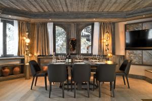 a dining room with a table and chairs at Les 2 chalets - Les appartements du Strato in Courchevel
