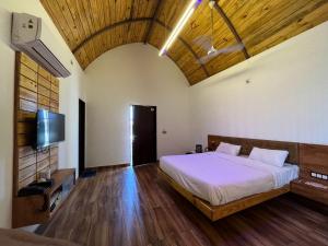 sypialnia z łóżkiem i telewizorem w pokoju w obiekcie Unique Resort And Restaurant w mieście Porbandar
