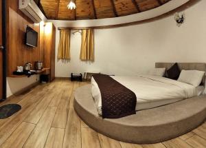 ein Schlafzimmer mit einem großen Bett in einem runden Zimmer in der Unterkunft Unique Resort And Restaurant in Porbandar