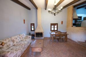 a living room with a couch and a table and a fireplace at Paraiso del Hueznar in Cazalla de la Sierra