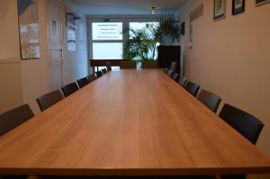 una sala de conferencias con una gran mesa de madera y sillas en Casa Camino, en Brujas
