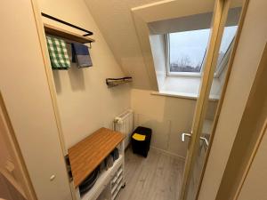 um pequeno quarto com uma mesa e uma janela em Haus Seefalke - 250 m zum Meer em Cuxhaven
