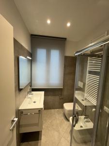 uma casa de banho com 2 lavatórios e um WC em House of Oscar em Adria