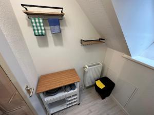 an attic room with a table and a stool at Haus Seefalke - 250 m zum Meer in Cuxhaven
