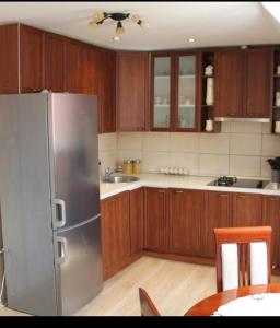 una cucina con armadi in legno e frigorifero in acciaio inossidabile di Apartment Home Popovic a Žabljak