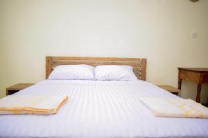 ein weißes Bett mit zwei Handtüchern darüber in der Unterkunft Luxe stay Airbnb in Mtwapa
