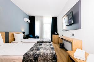 アンタルヤにあるララ ワールド ホテルのベッド2台とテレビが備わるホテルルームです。