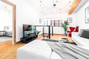 Newtown Loft Apartment - Smart TV- WIFI - Parking 3NT في برمنغهام: غرفة معيشة مع أريكة بيضاء وتلفزيون