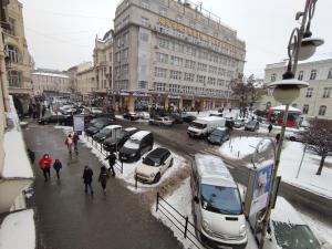 une rue de la ville avec des voitures garées dans la neige dans l'établissement Апартаменты на 6х Проспект шевченка центр, à Lviv
