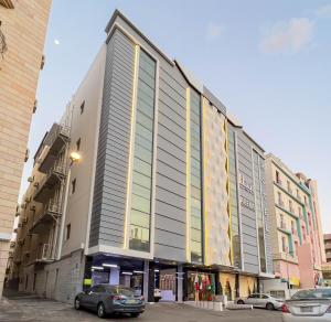 un gran edificio con coches estacionados en un estacionamiento en Abela Alhamra Jeddah - Palestine Branch, en Yeda