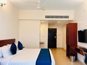 a bedroom with a bed and a flat screen tv at Le MIAMI RESORT in Pondicherry +46 photos