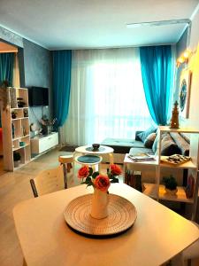 uma sala de estar com uma mesa com um vaso sobre ela em Апартамент BLUE SUMMER - уют, близо до морето em Burgas
